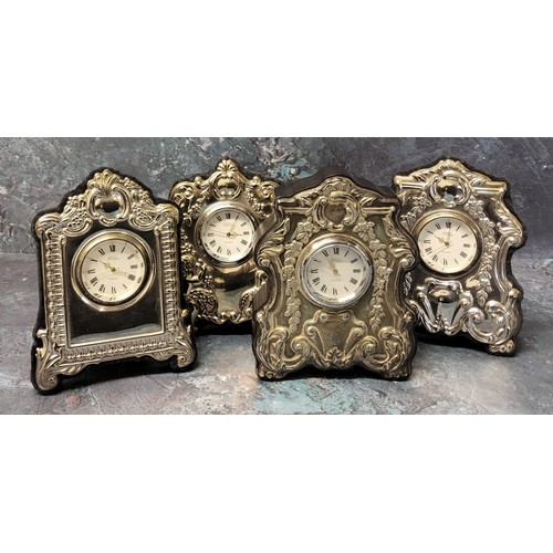 218 - Three silver mounted miniature clocks in form of shaped mantel clocks, embossed silver panels to fro... 