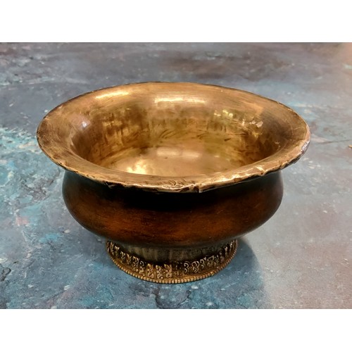 219 - A Tibetan white metal mounted indigenous timber circular libation bowl, raised foot ring, 10cm diam