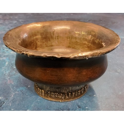 219 - A Tibetan white metal mounted indigenous timber circular libation bowl, raised foot ring, 10cm diam