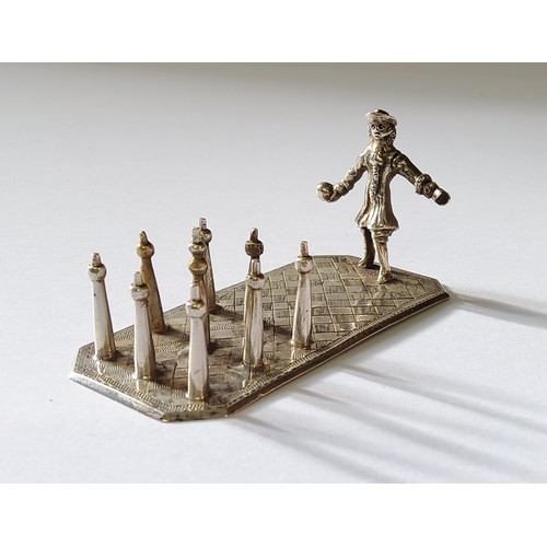 255 - A Continental white metal miniature of a man playing street ninepins on a rectangular base engraved ... 