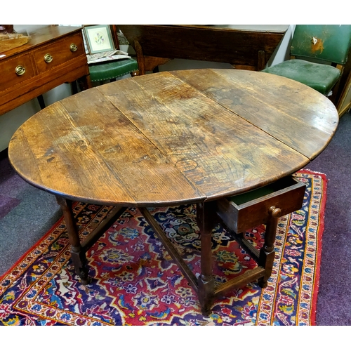 64 - An early George III English oak gateleg drop leaf dining table, pegged construction, single drawer t... 