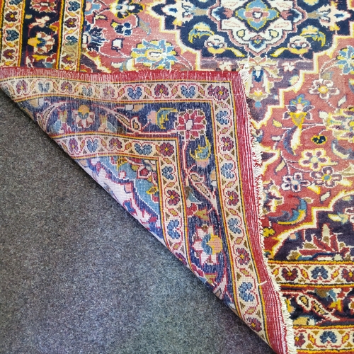 65 - A late 19th/ early 20th century Afghan rug in rich tones of red, gold and blues