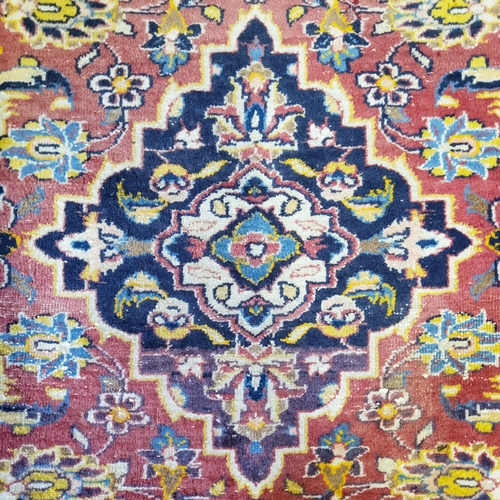 65 - A late 19th/ early 20th century Afghan rug in rich tones of red, gold and blues