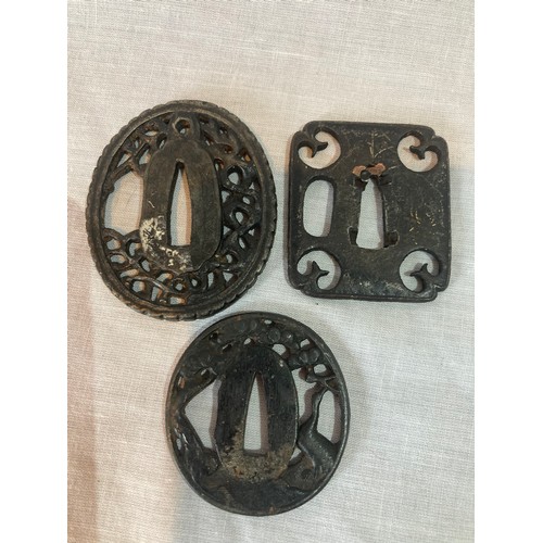 251 - A Japanese iron tsuba, oval, pierced with blossoming prunus, 4.5cm wide;  others (3)