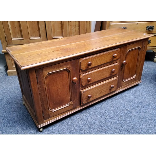 397 - A modern English oak side unit, with three long graduated drawers flanked by a pair of fielded panel... 