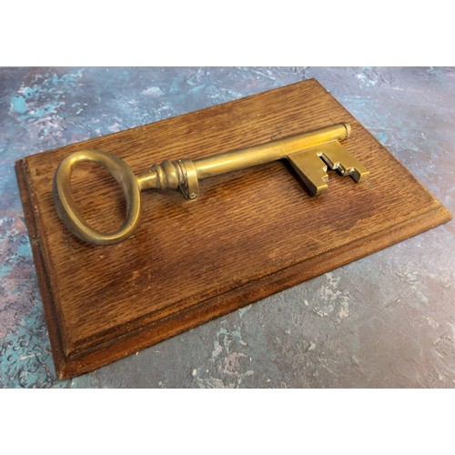 55 - A late 19th century novelty desk letter clip, in the form of key,  oak rectangular base, 25cm l... 