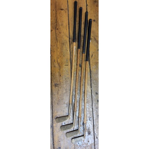 61 - Early Golfing Interest- a set of four Edwardian hickory shafted and brass putter golf clubs, each ma... 