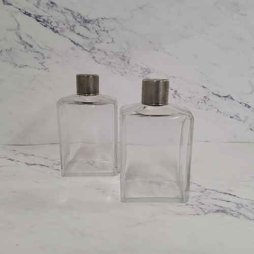 314 - A pair of George V silver and clear glass scent flasks, the covers engine turned, 12.75cm high, Lee ... 