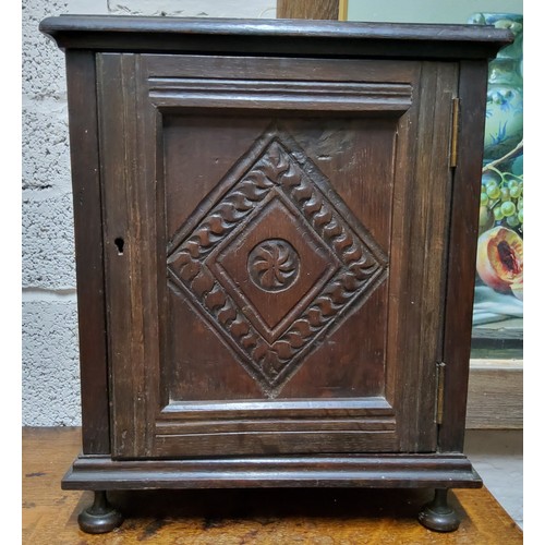 487 - An early 20th century oak table top, smokers cabinet, carved ;lozenge panelled door, fitted interior... 