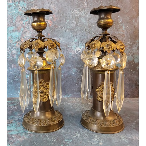 56 - A pair of Regency bronze candle lustres, cast with stylised leaves, clear glass prismatic droplets, ... 