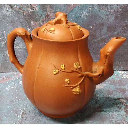 129 - A Chinese Yixing teapot, in relief with blossoming prunus branches, 15cm high