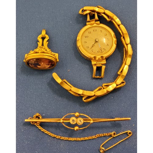 342 - WITHDRAWN - A lady's 9ct gold watch;  a gold coloured metal fob, purple stone;  a gold coloured meta... 