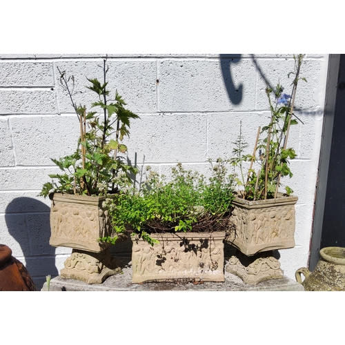 415 - Three decorative reconstituted stone garden planters decorated in relief with putti