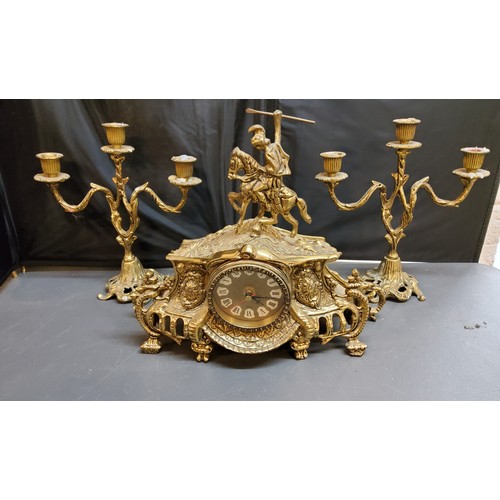 25 - A 20th century gilt metal clock garniture, quartz clock, the case surmounted with a knight, three li... 