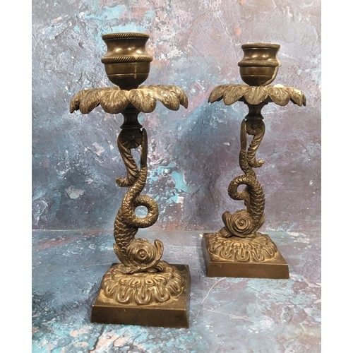 119 - A pair of Regency bronze candlesticks, everted leafy sconces, dolphin columns, square bases, 18.5cm ... 