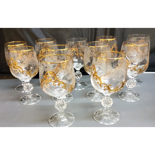 126 - A set of eleven wine glasses, each applied in relief in gilt with scrolls, 15.5cm high