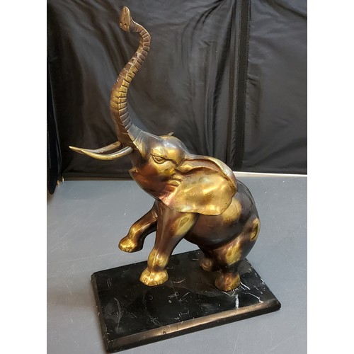 133 - 20th century, gilt bronze, elephant, with front legs and trunk raised, 'marbled' base, 46cm high