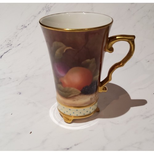 7 - An English porcelain mug, painted Marian Greaves, with ripe fruit on a mossy bank, picked out in gil... 