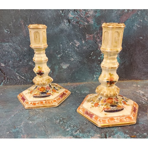 15 - A pair of 19th century Meissen candlesticks, decorated in blue red and green, hexagonal sconces and ... 