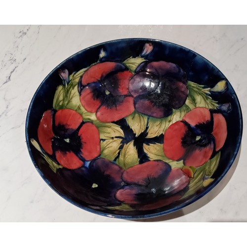 72 - A Moorcroft Pansy pattern circular bowl,  tubed lined with  flowerheads, on a cobalt blue ... 