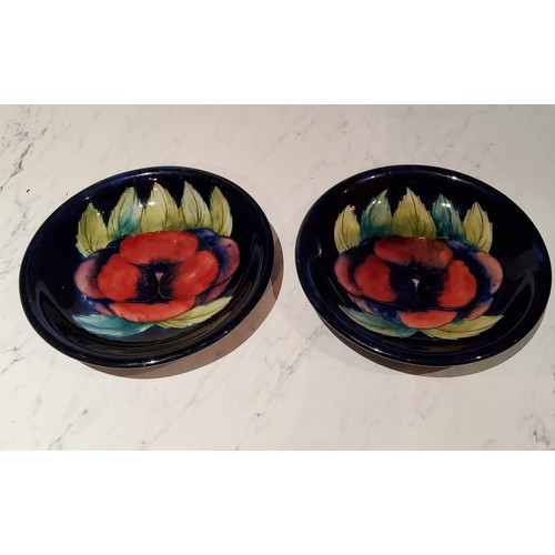 74 - A pair of Moorcroft Pansy pattern circular plates, tubed lined with large flowerhead, on a cobalt bl... 