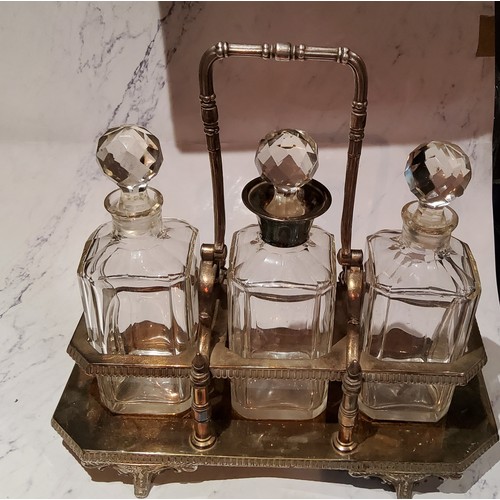 79 - A plated three bottle tantalus, canted square bottles, swing handle, 37cm wide