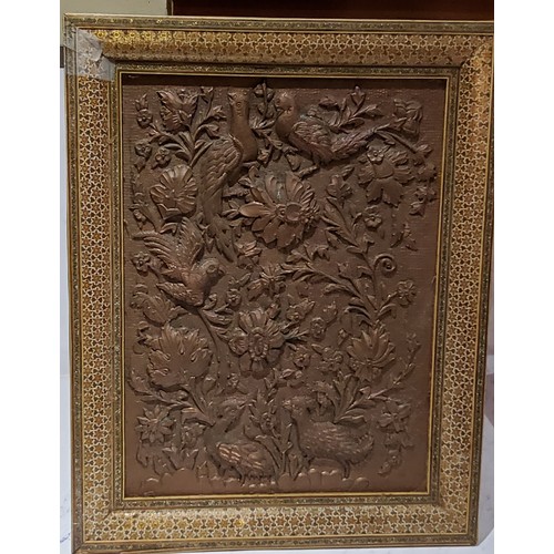 207 - An Islamic copper panel, embossed with birds and foliage, Kahatan marquetry frame, 49cm x 39cm