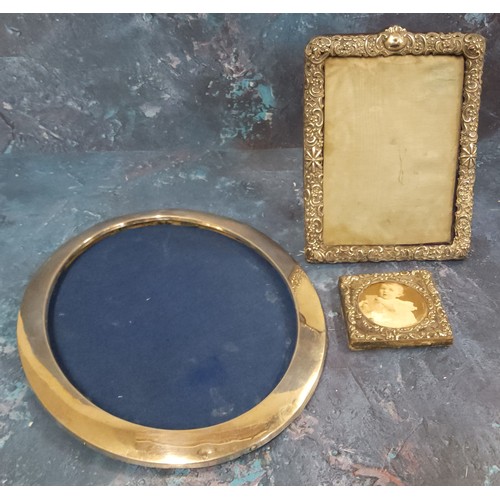 128 - A George V silver oval easel photograph frame, 25cm high, 19.5cm high, Birmingham 1916;  another, Vi... 