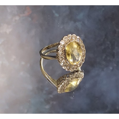 155 - An 18ct white gold yellow sapphire & diamond cluster ring, the central oval yellow sapphire meas... 