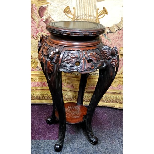 392 - A 19th century Chinese hardwood jardiniere / temple vase stand, carved with oriental iris flower hea... 