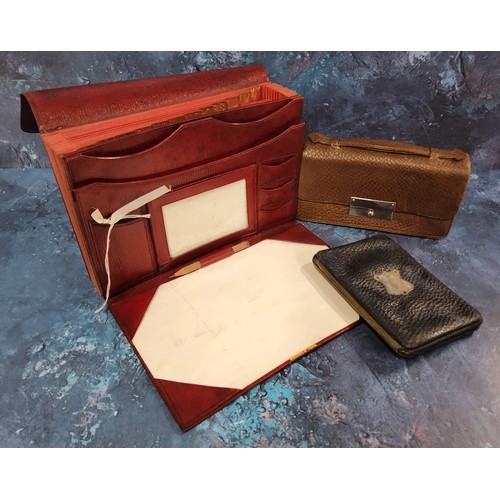 216 - An early 20th century red morocco leather stationery case,  writing surface, stamp and paper pouches... 