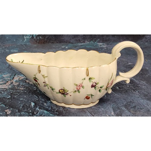 364 - A Bristol  fluted sauceboat,  painted with floral swags, outlined in gilt,  the spout with leafy wre... 