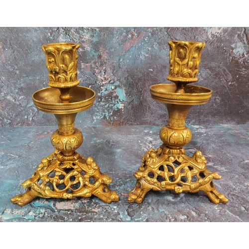 506 - A pair of French gilt bronze candlesticks, the sconces cast with leaves, triform bases pieced and ca... 