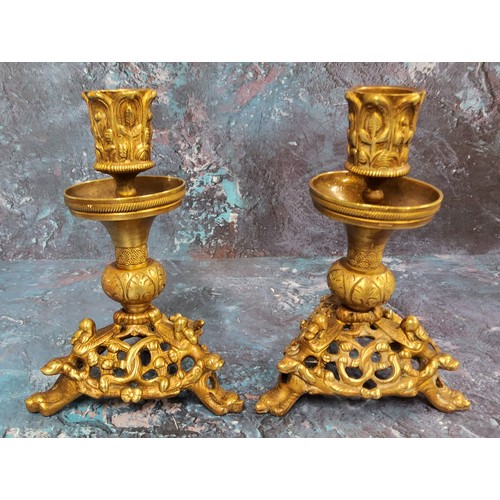 506 - A pair of French gilt bronze candlesticks, the sconces cast with leaves, triform bases pieced and ca... 