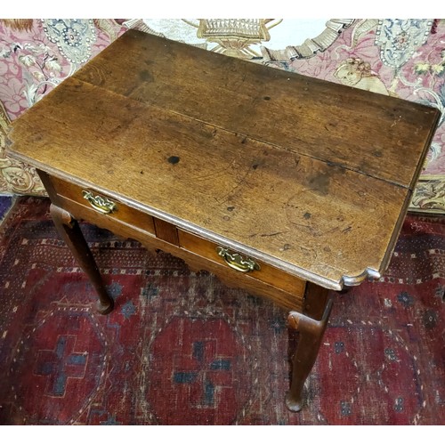 554 - A George III oak lowboy or side table, oversailing shaped rectangular top with moulded edge above tw... 