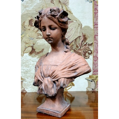 567 - French School, early 20th century, a signed terracotta bust, of a young lady with floral chaplet, 46... 