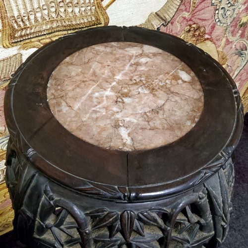 569 - A Chinese hardwood jardiniere stand, circular top with inset soapstone roundel, above a deep frieze ... 