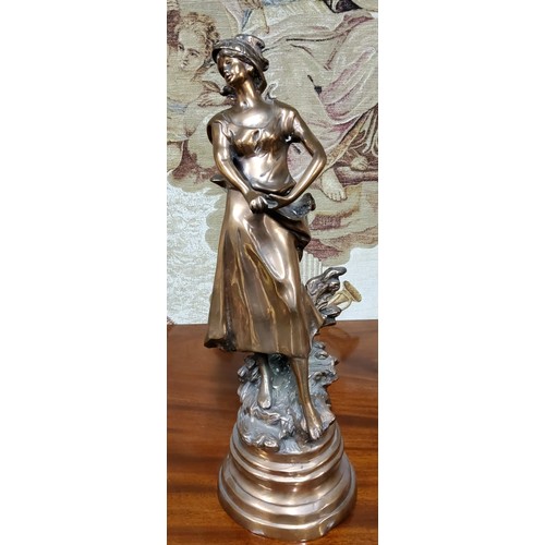 666 - A 19th century French bronze of a lady during the harvest, raised on a later base, 55cm high