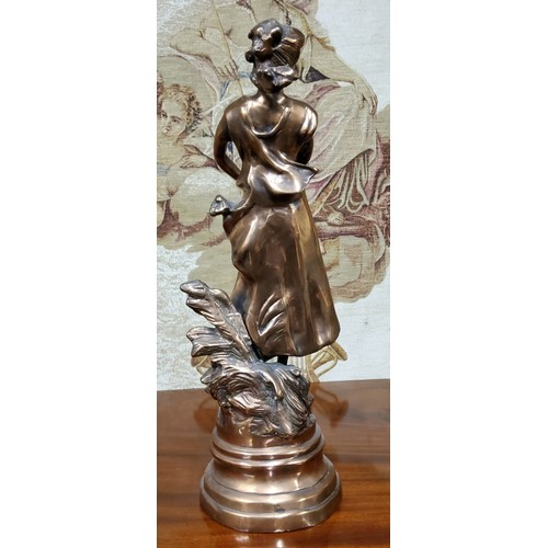 666 - A 19th century French bronze of a lady during the harvest, raised on a later base, 55cm high