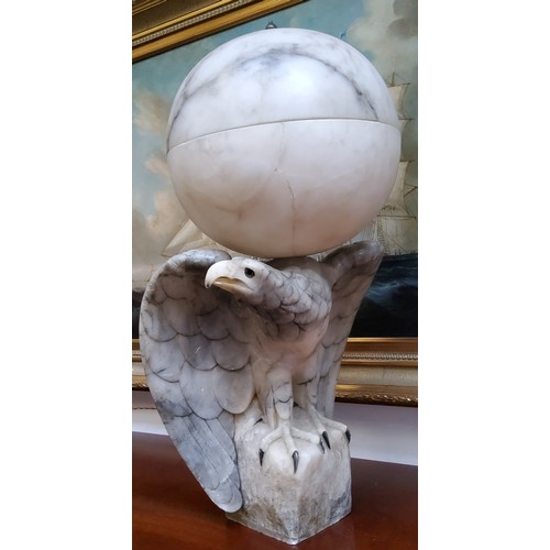 671 - An impressive Art Deco Italian alabaster table lamp in the form of a golden eagle, surmounted with a... 