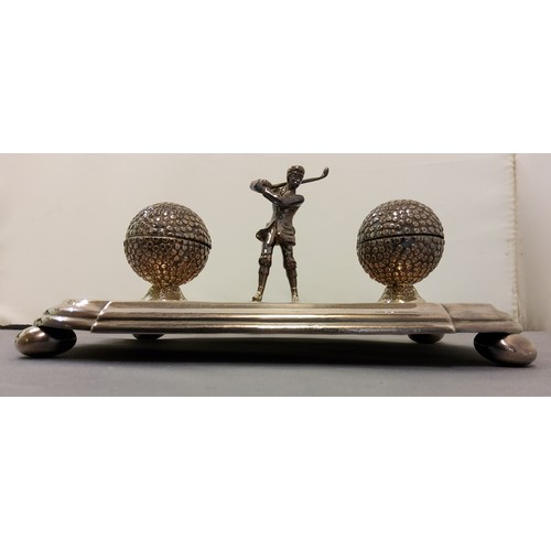 658 - A silver plated desk standish, with golfer flanked by two golf ball wells, pen apertures, bun feet, ... 