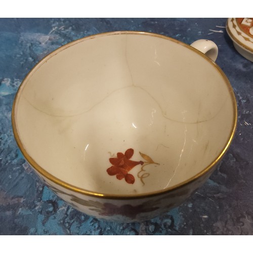 388 - A Pinxton Bute shaped teacup, pattern 312 decorated with a broad band of scrolling lilies in red and... 