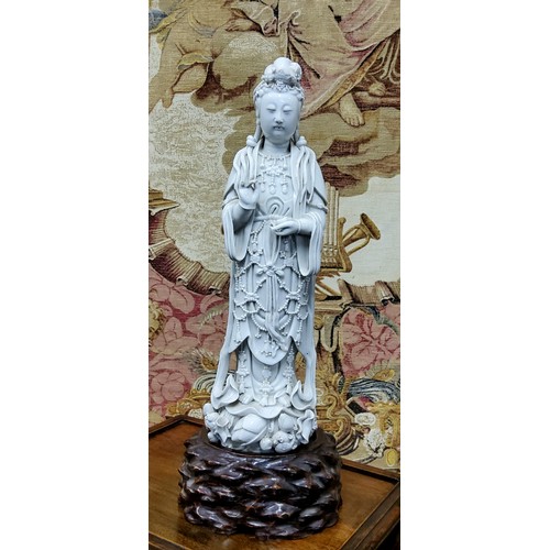 390 - An 18th/19th century Chinese blanc de chine figure, of Guanyin, the deity modelled standing wearing ... 