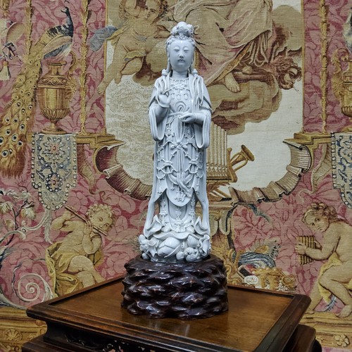 390 - An 18th/19th century Chinese blanc de chine figure, of Guanyin, the deity modelled standing wearing ... 