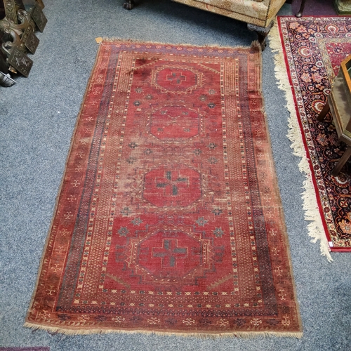 774 - A 19th century Afghan rug in tones of maroon,  navy and gold