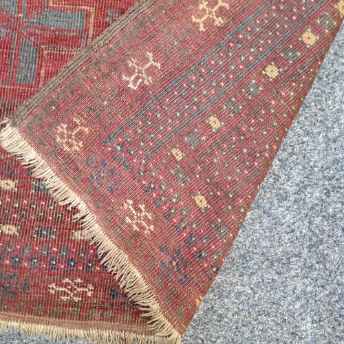 774 - A 19th century Afghan rug in tones of maroon,  navy and gold