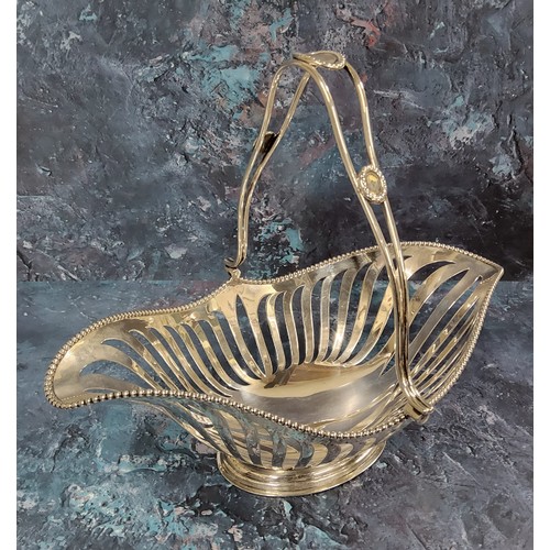 120A - An Edwardian silver swing-handled bread basket, the handle with three beaded bosses, beaded rim and ... 