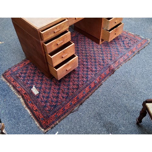 909 - A 19th century hand knotted Eastern rug, red ground, 83in x 44in