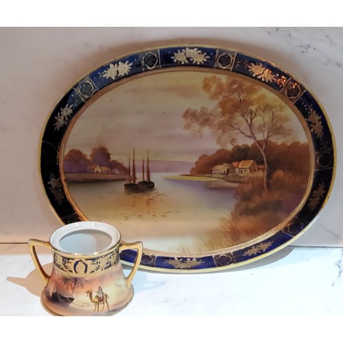 39 - A Noritake oval cabaret tray, painted with riverscape, cobalt banded border, 32cm wide, printed mark... 