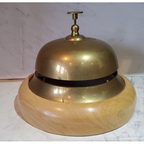 68 - An oversized brass desk/counter bell, beech base, 21.5cm diam